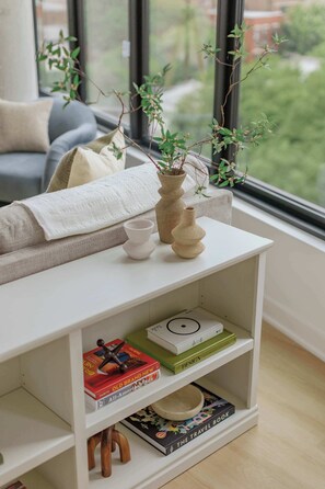 A bookshelf with books, a vase, and a plant. - Luxury Penthouse Collection PH4 - Fulton Market (Chicago)