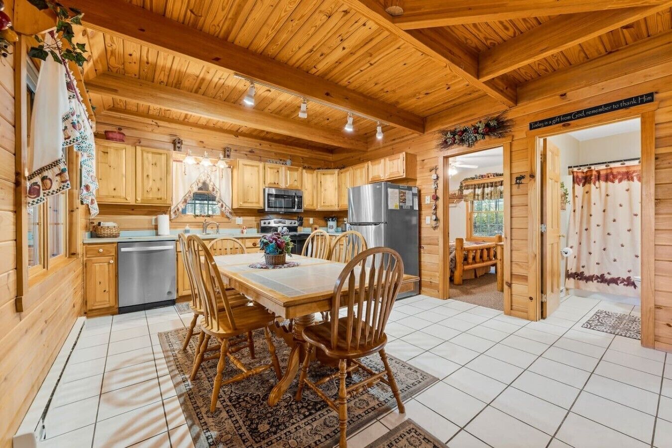 L’intérieur d’un chalet en bois comprend une cuisine, un coin repas et une porte visible qui donne sur l’extérieur.