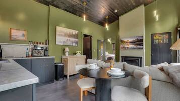 A modern kitchen with a dining area, a sofa, and a fireplace.