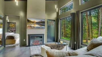 A modern interior with a fireplace, large windows, and a cozy seating area.