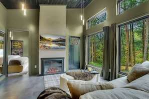 A modern interior with a fireplace, large windows, and a cozy seating area.