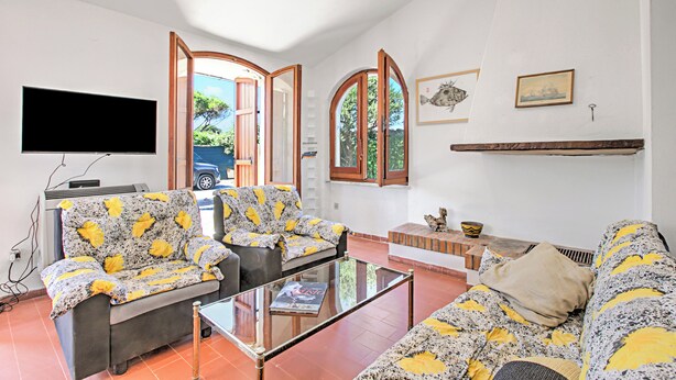 A living room with a sofa set, a coffee table, a flat-screen TV, and a fireplace.