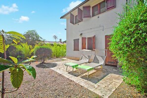 Un bâtiment doté d’un patio, d’un petit jardin et d’une clôture en bois.