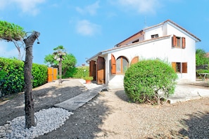 A two-story house with a white exterior and brown shutters, surrounded by greenery and gravel pathways. - Villa Janela Escape & Retreat, 30m From the Beach (Orbetello)