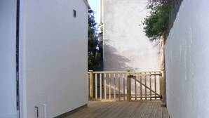 A narrow wooden deck with a wooden gate, white walls, and a small window. - Funky Easton flat with parking (Greenbank)