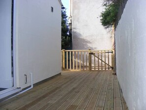 A narrow wooden deck with a wooden gate, white walls, and a small window. - Funky Easton flat with parking (Greenbank)