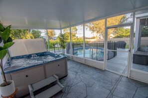 A covered outdoor area with a hot tub, a pool, and a patio with seating. - Fun Hot Tub & Pool Beach Home - Pet Friendly (Port St. Lucie)