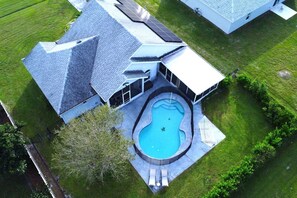 Une propriété résidentielle dotée d’une piscine, d’un patio couvert et de panneaux solaires.