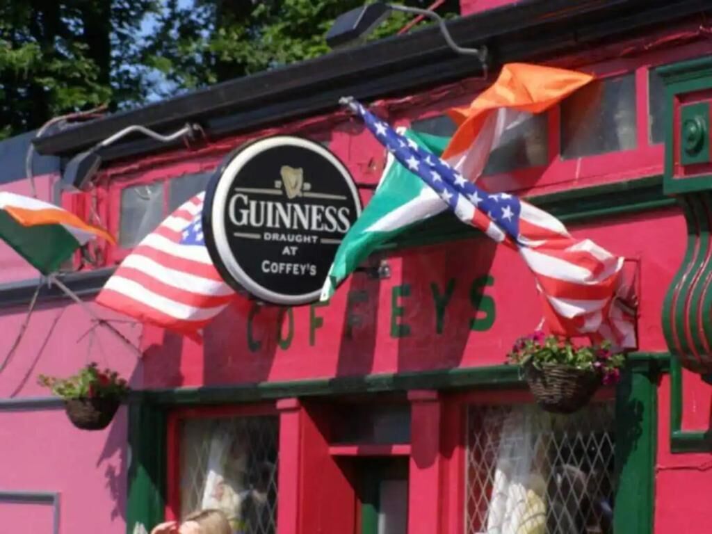Un bâtiment orné d’une enseigne Guinness, de drapeaux et du mot « COFFEYS » sur la façade.