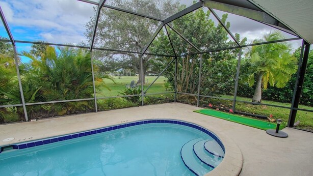 A swimming pool with a 3ft depth marker, surrounded by a covered area with a view of a golf course. - 3/2 Heated Pool • Close to Beach • Trails • Golf (Port St. Lucie)