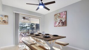 A dining area with a table set for four, a ceiling fan, and a large window with a view of the outdoors. - 3/2 Heated Pool • Close to Beach • Trails • Golf (Port St. Lucie)