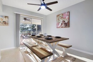 A dining area with a table set for four, a ceiling fan, and a large window with a view of the outdoors. - 3/2 Heated Pool • Close to Beach • Trails • Golf (Port St. Lucie)