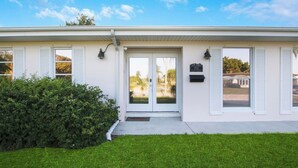 A two-story building with a white exterior, a front door with glass panels, and a mailbox on the right side. - 3/2 Heated Pool • Close to Beach • Trails • Golf (Port St. Lucie)