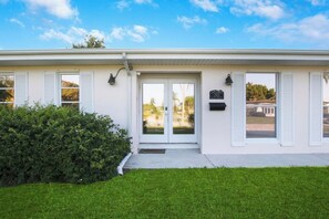 A two-story building with a white exterior, a front door with glass panels, and a mailbox on the right side. - 3/2 Heated Pool • Close to Beach • Trails • Golf (Port St. Lucie)