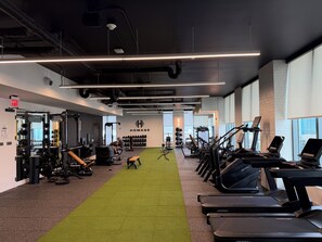 A gym with weightlifting equipment, treadmills, and a green carpet. - Botanical Boutique Studio in Miami Downtown (Miami)
