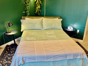 A bed with a patterned bedspread, a bedside lamp, and a wall-mounted plant. - Botanical Boutique Studio in Miami Downtown (Miami)