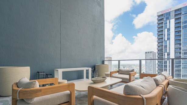 En balkon med siddepladser og fjernsyn med udsigt over bybilledet.
