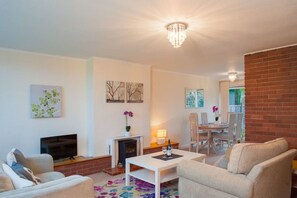 A living room with a fireplace, a television, and a dining area with chairs and a table. - Chippings - Village life in the city. MyCityHaven (Stapleton)