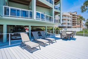 Un hotel de diverses plantes amb zona de piscina, mobiliari exterior i aparcament cobert.