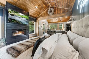 Quarto com lareira, janela grande e vista para o exterior.