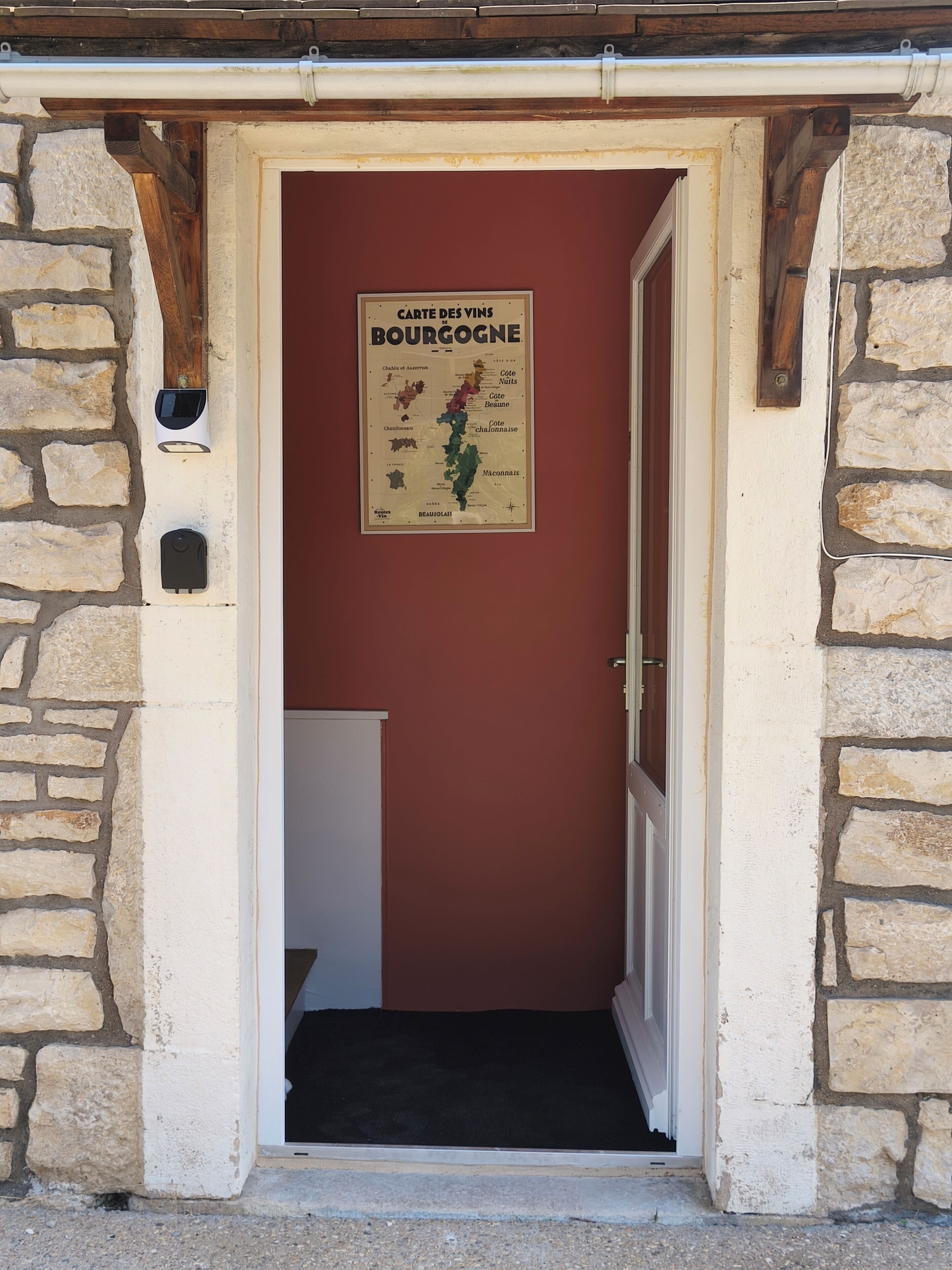 Une porte donnant sur un mur en pierre, avec un cadre en bois et une affiche accrochée au mur.
