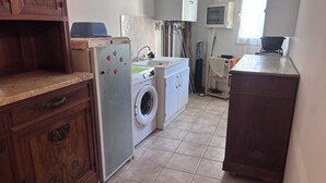 Una cucina con lavatrice, mobili e un piano di lavoro.