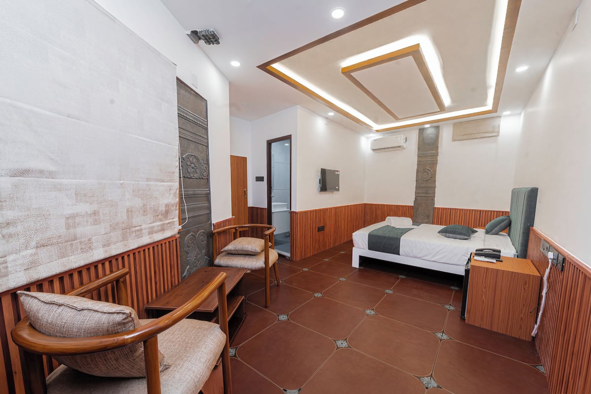 Une chambre à coucher avec un lit, des meubles en bois, une télévision et un sol carrelé.