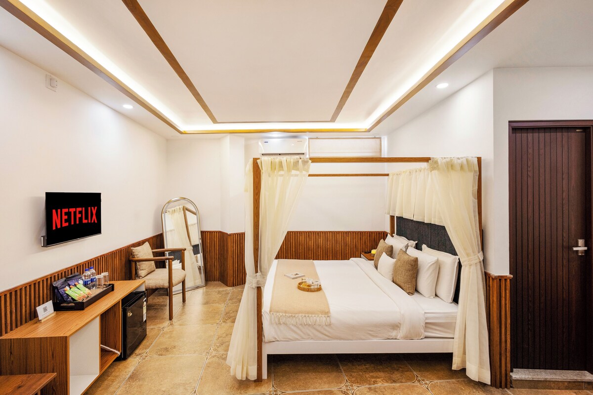 A hotel room with a bed, a TV, a desk, and a wardrobe.