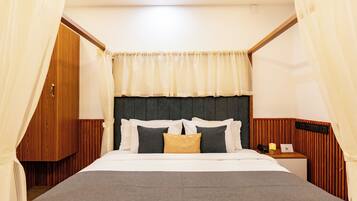 A neatly made bed with a headboard, a bedside table with a lamp, and a curtain.