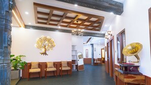 Una zona de recepción con un mostrador de madera, una gran escultura de árbol montada en la pared y un tocadiscos antiguo.