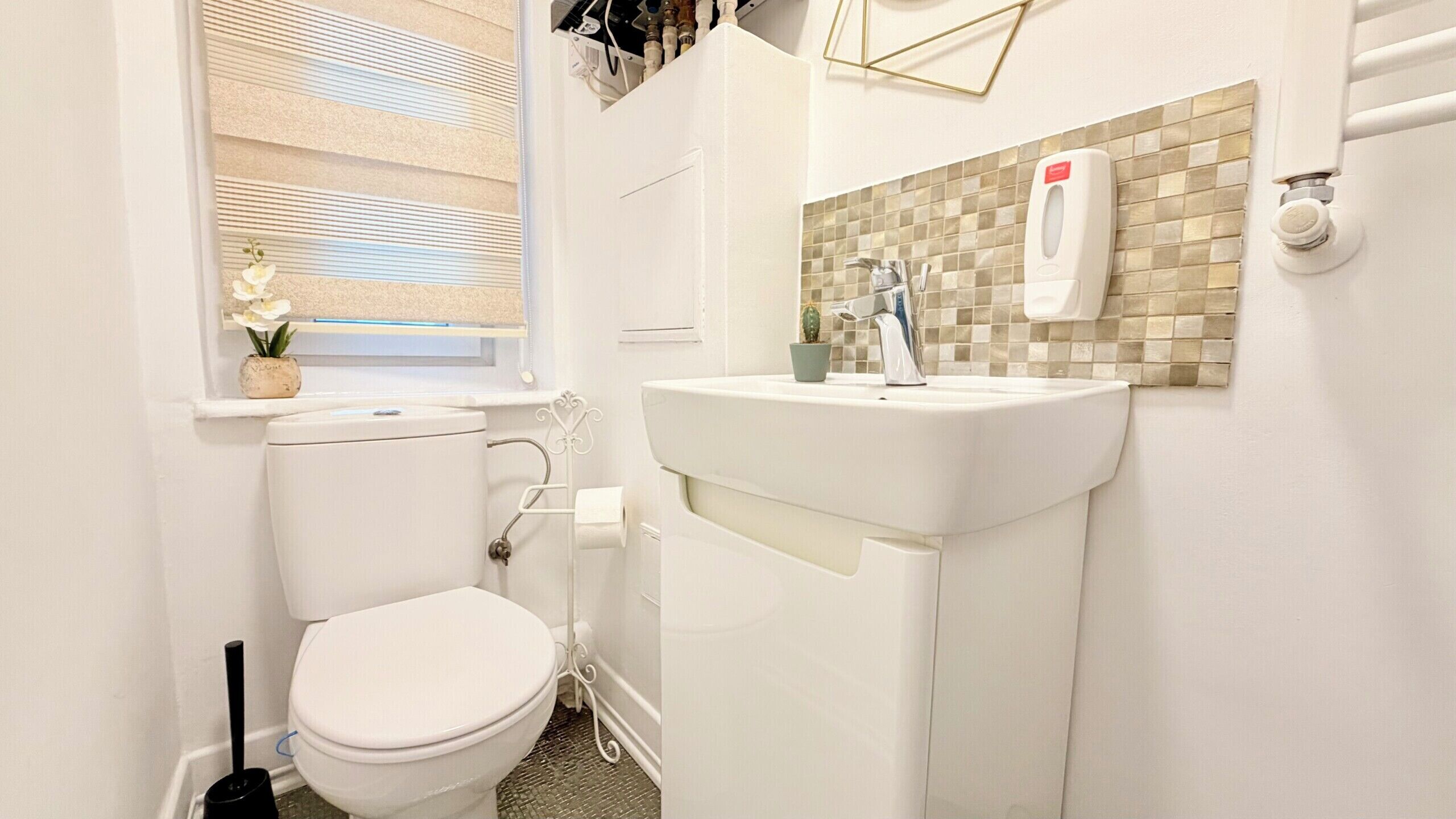 A compact bathroom with a toilet, sink, and window.
