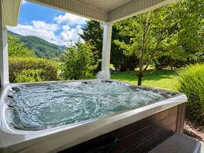 A hot tub with a view of a lush garden and mountains. - Private 27 Acre Estate ~ Mountain Views + Barn (Johnson City)