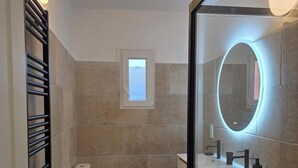A modern bathroom with a toilet, sink, and mirror. - Fully renovated apartment in the heart of Propriano (Propriano)