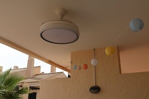A ceiling fan, a wall-mounted light fixture, and a string of paper lanterns. - Apartment 'Casa Maje' with Shared Terrace and Wi-Fi (Fuente Álamo de Murcia)