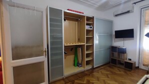 A room with a wardrobe, a television, and a wooden floor. - Casa Vitto 1-Room Apartment, A/C, 8 min from the airport, 10 min from the beach by car or bus (Genova)