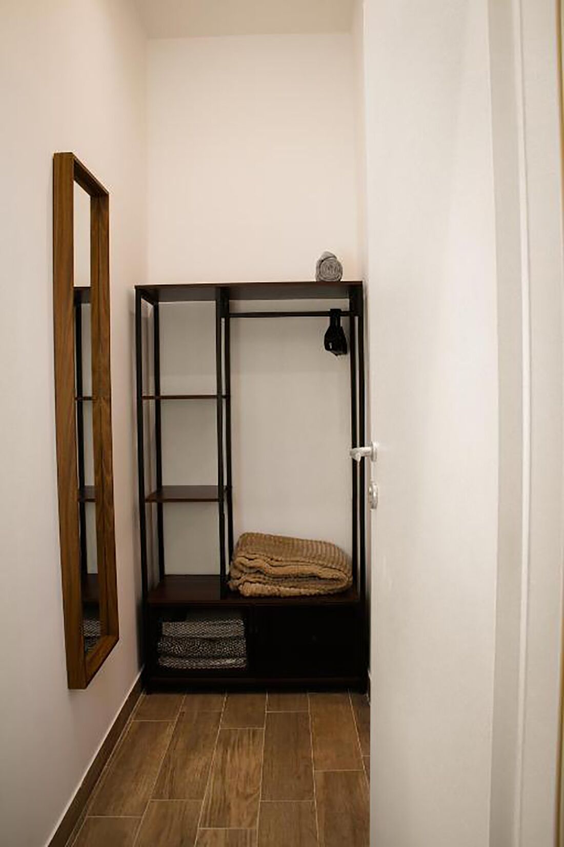 Ein kleiner, abgeschlossener Raum mit einem Etagenbett, einer Holztür und einem Spiegel links.