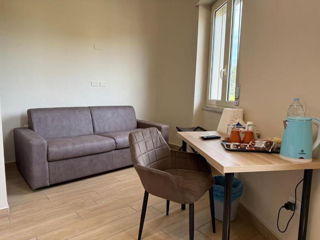 Deluxe Quadruple Room | Living area | TV