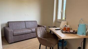 Deluxe Quadruple Room | Living area | TV