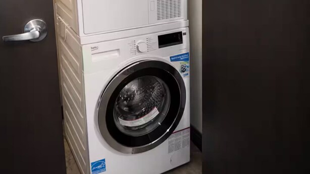 Eine gestapelte Waschmaschine und ein Trockner, mit Tide Waschmittel obenauf.