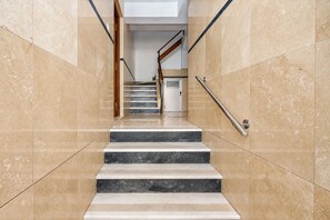 A staircase with marble steps and handrails, leading to a door at the top. - GuestReady - Modern escape in Sevilla (Sevilla)