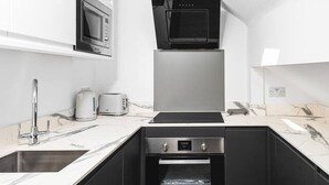 Eine moderne Küche mit Oberlichter, einer Mikrowelle, einem Herd und einem eingebauten Backofen.
