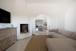 A modern living room with a flat-screen TV, a fireplace, a sofa, and a kitchen visible through an archway. - A stunning villa in Francavilla Fontana offering a relaxing, nature-filled stay, complete with a private garden, saltwater pool, and parking. Located just a short drive from the historic center, it is about 30 minutes by car from seaside spots like Lepor (Francavilla Fontana)