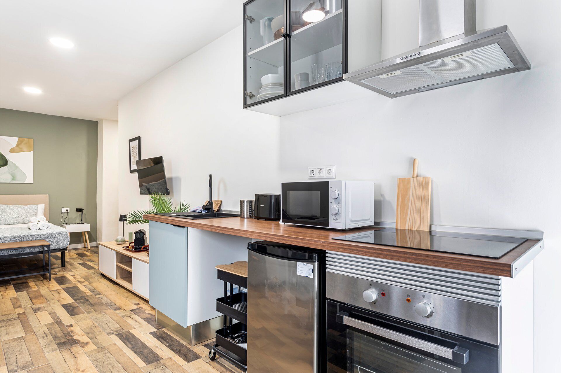 A modern kitchen with a built-in oven, microwave, and a stainless steel range hood.