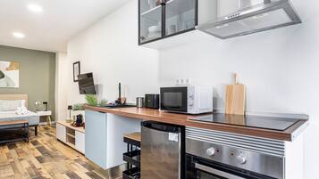 A modern kitchen with a built-in oven, microwave, and a stainless steel range hood.