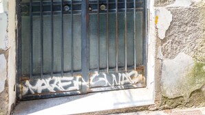 Una reixa de metall desgastada amb un senyal del número 2, una finestra circular i una base de formigó.
