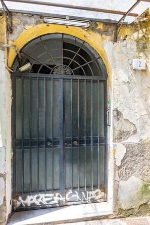 A weathered metal gate with a number '2' sign, a circular window, and a concrete base. - PizzArcHouse - One Bedroom Apartment, Sleeps 4 (Naples)