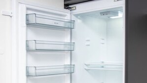 Ett kylskåp med öppna hyllor, flera genomskinliga hyllplan och ett frysfack längst ner.