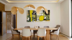A dining area with a round table, six chairs, and three hanging light fixtures. - Villa Dalaoui - Five Bedroom Villa, Sleeps 10 (Douar Moulay Abbas)