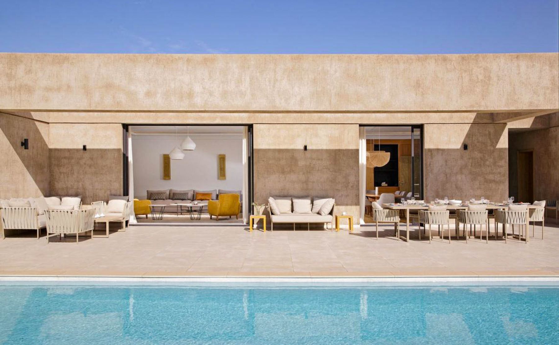 A modern outdoor pool area with seating arrangements and a pool.