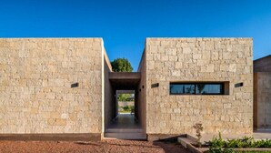 A modern building with a symmetrical design, featuring a central pathway leading to a covered entrance. - Villa Dalaoui - Five Bedroom Villa, Sleeps 10 (Douar Moulay Abbas)